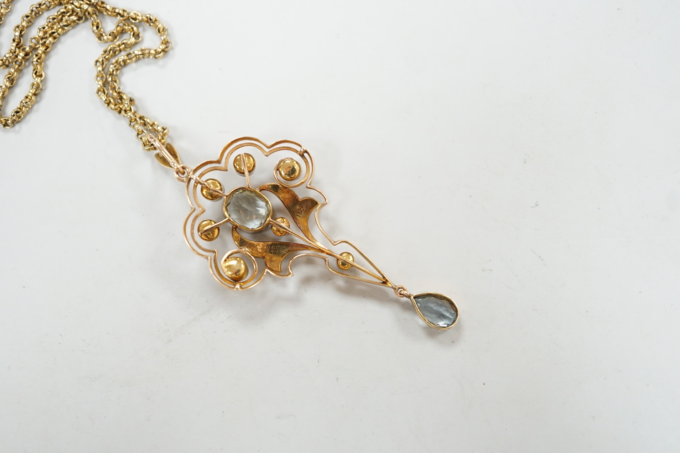 An Edwardian 15ct, aquamarine and seed pearl set drop pendant, 56mm, gross weight 5.3 grams, on a gilt metal chain.